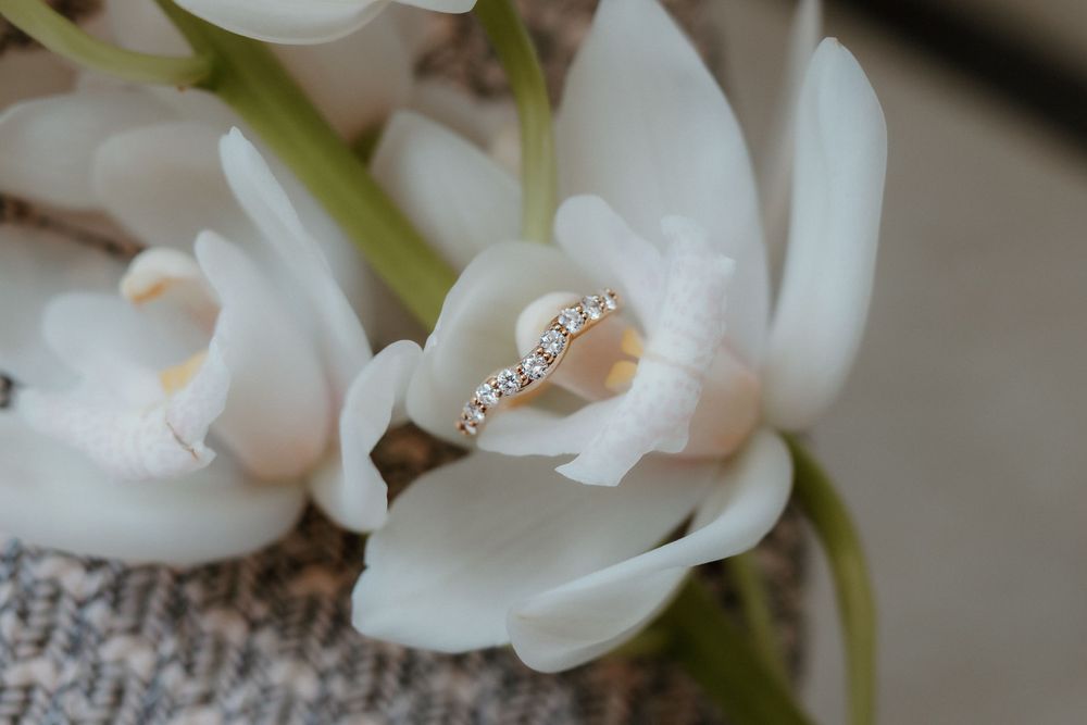 Elegant engagement ring nestled among white orchid petals.