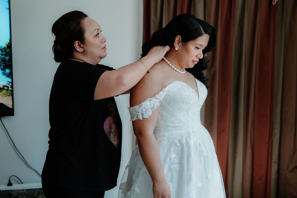 A wedding dress being adjusted and fitted during bridal preparations.