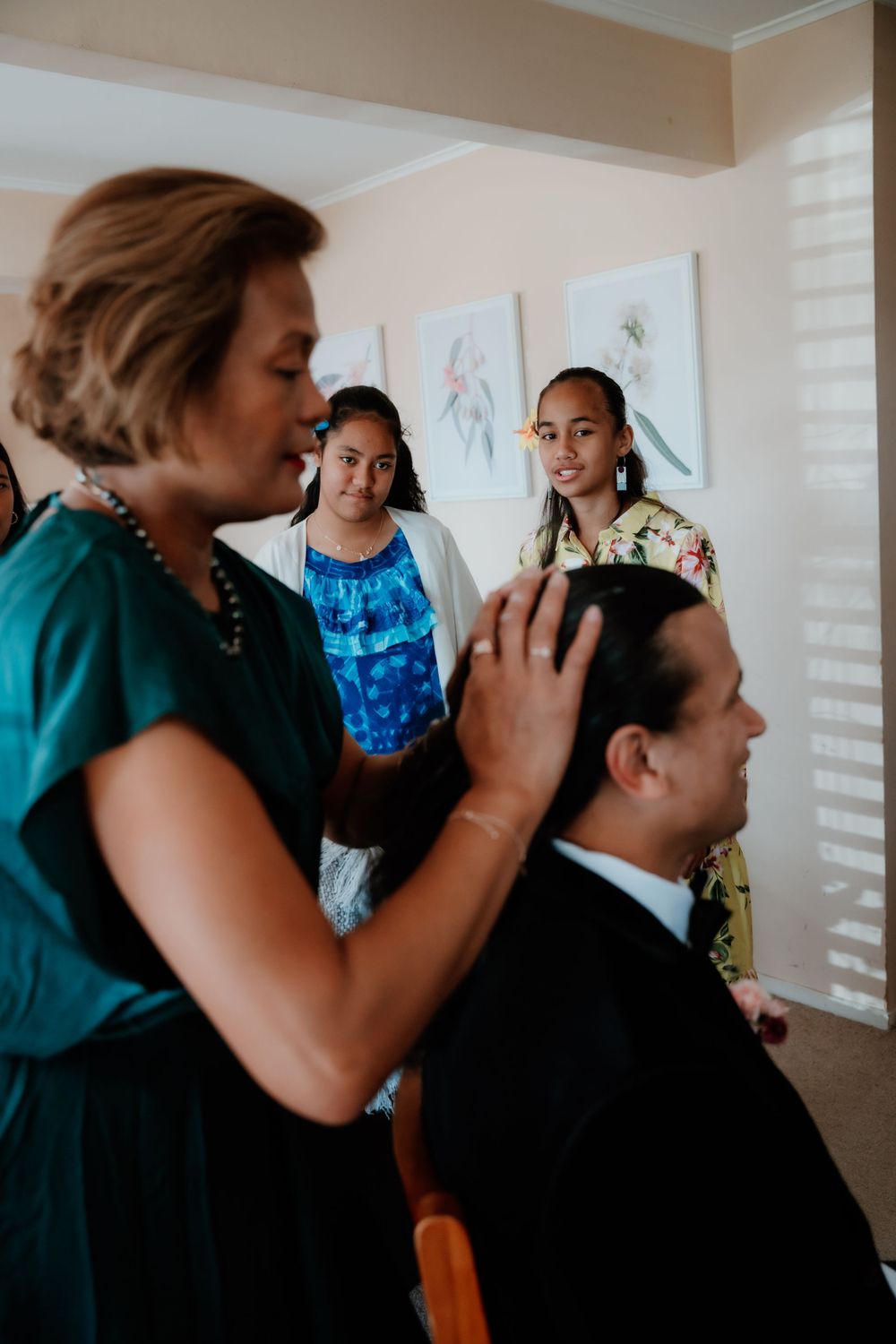 Wedding preparation scene showing final touches being made to the groom's attire.