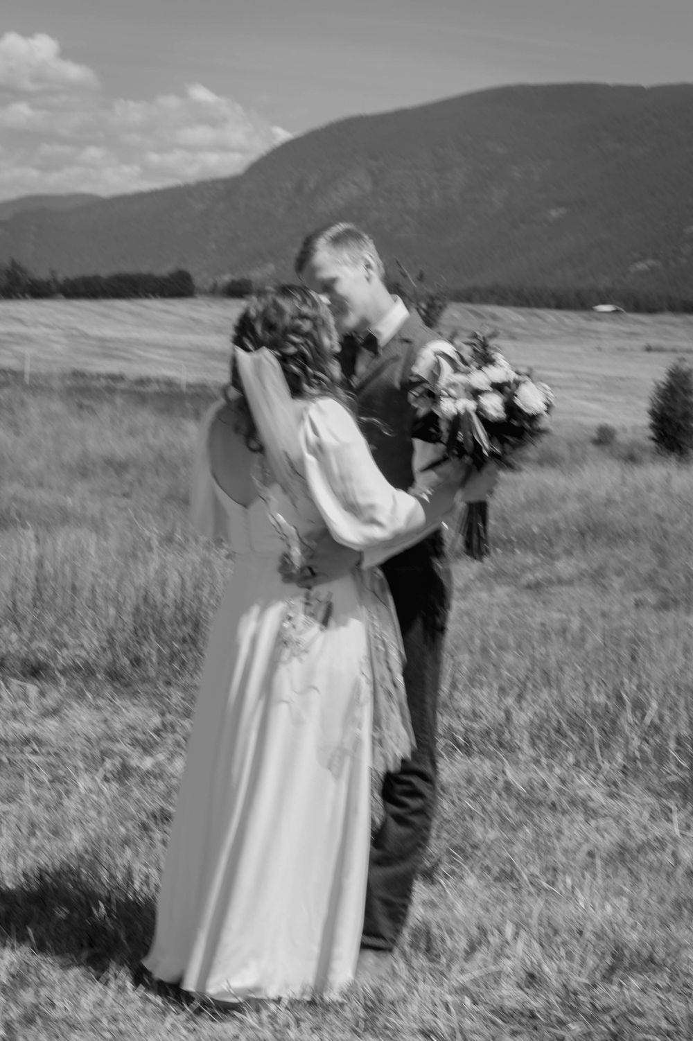 Motion blur of newly married couple in front of large mountains on US, Canada border in Bonners Ferry.