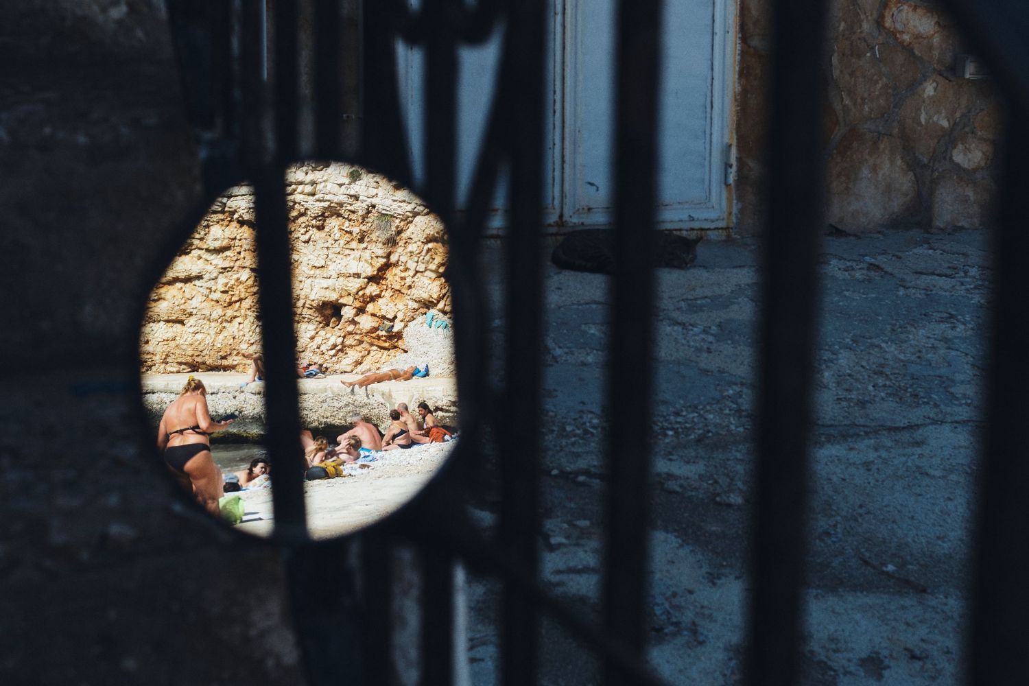 Creative circular view through iron bars focusing on stone wall texture.