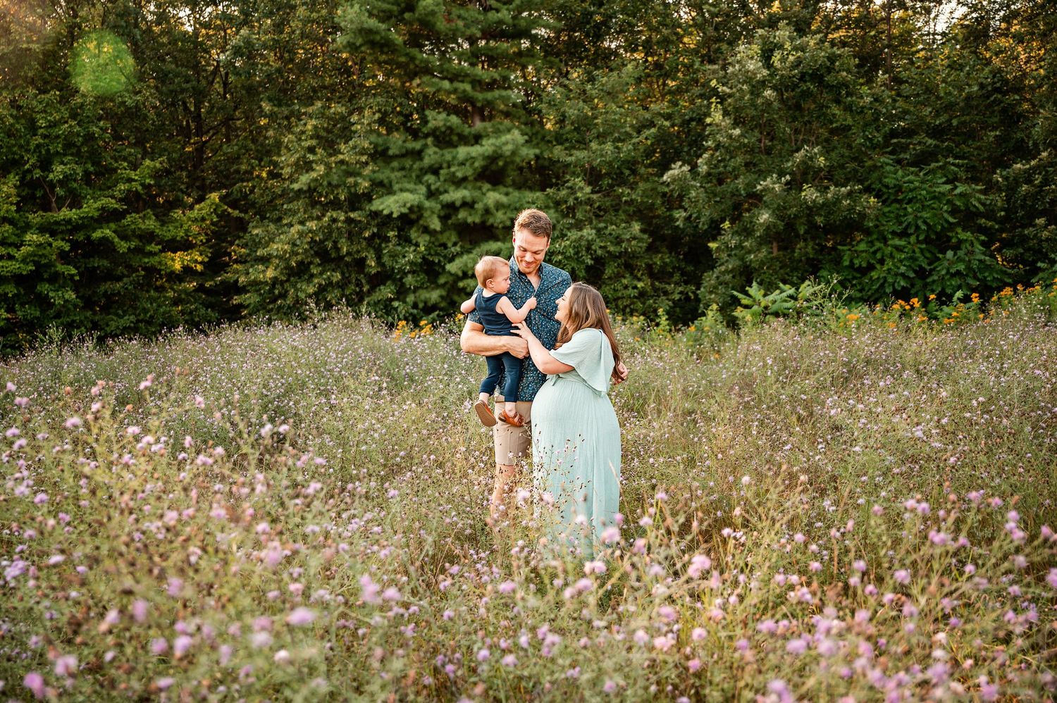 A couple shares a romantic moment together in a wildflower meadow on a sunny afternoon.