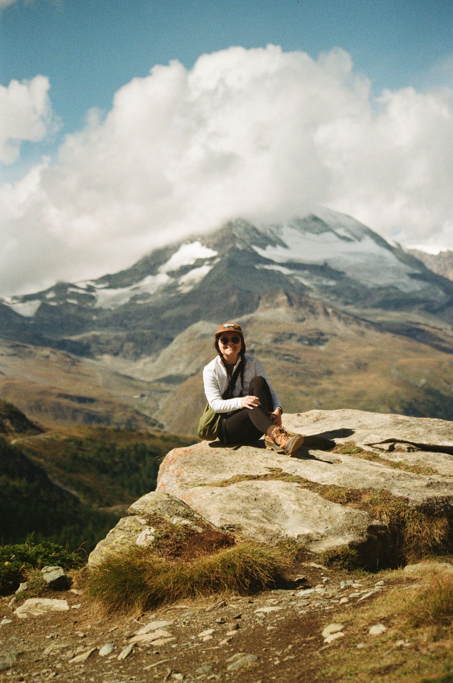 Film photo of myself sitting on rock with the Matterhorn in background in Zermatt, Switzerland.