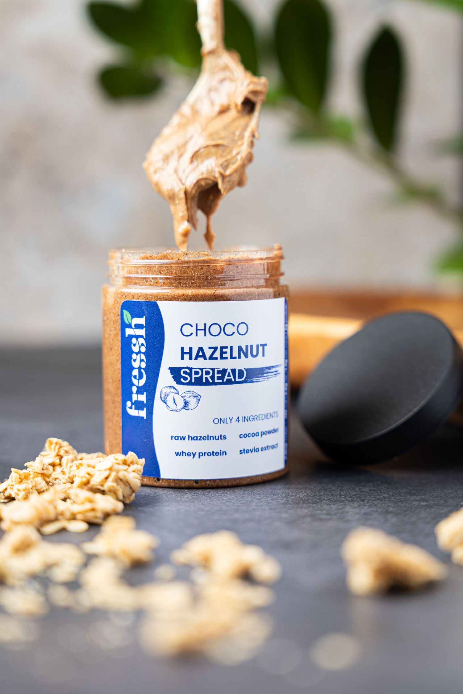 Fressh Choco Hazelnut Spread jar with a spoon, made with raw hazelnuts, cocoa powder, whey protein, stevia.