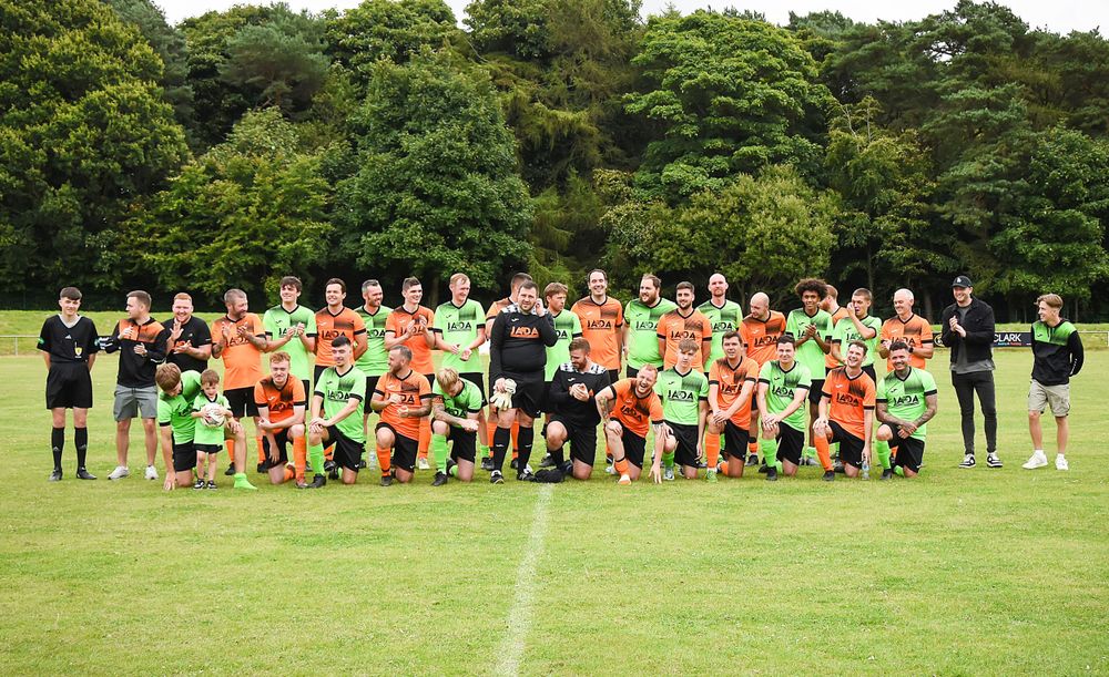 Group shot of charity event JADA football match at Warout stadium. The two teams are combined before the match begins.