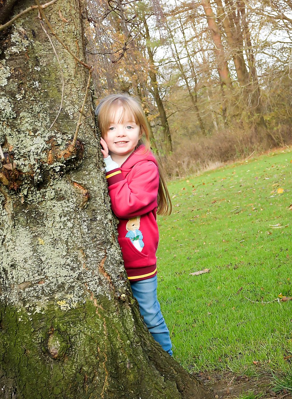 Peeking behind a tree on a crisp Autumn family session at Balbirnie.