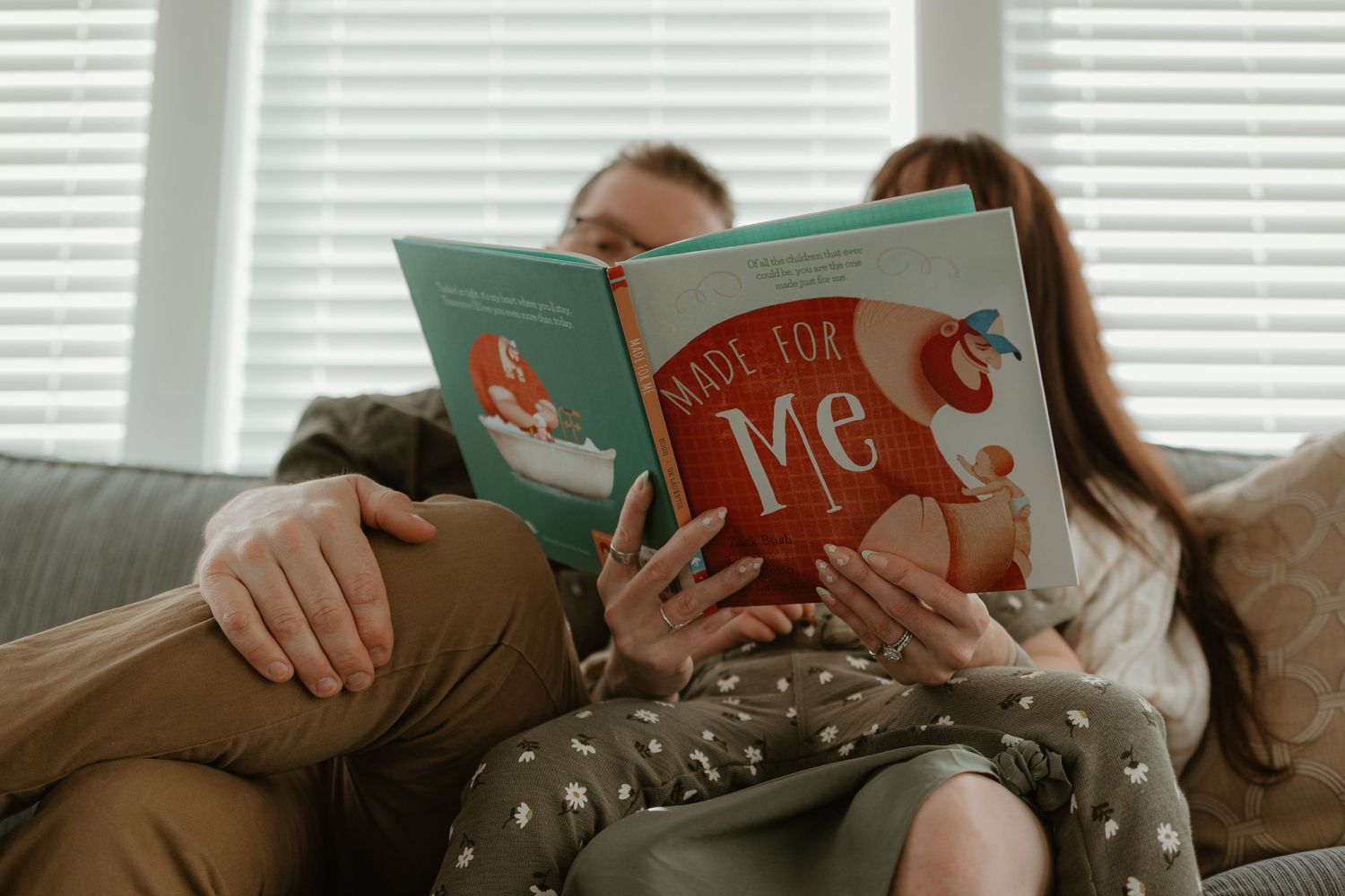 A cozy scene of reading together on the couch with children's books.
