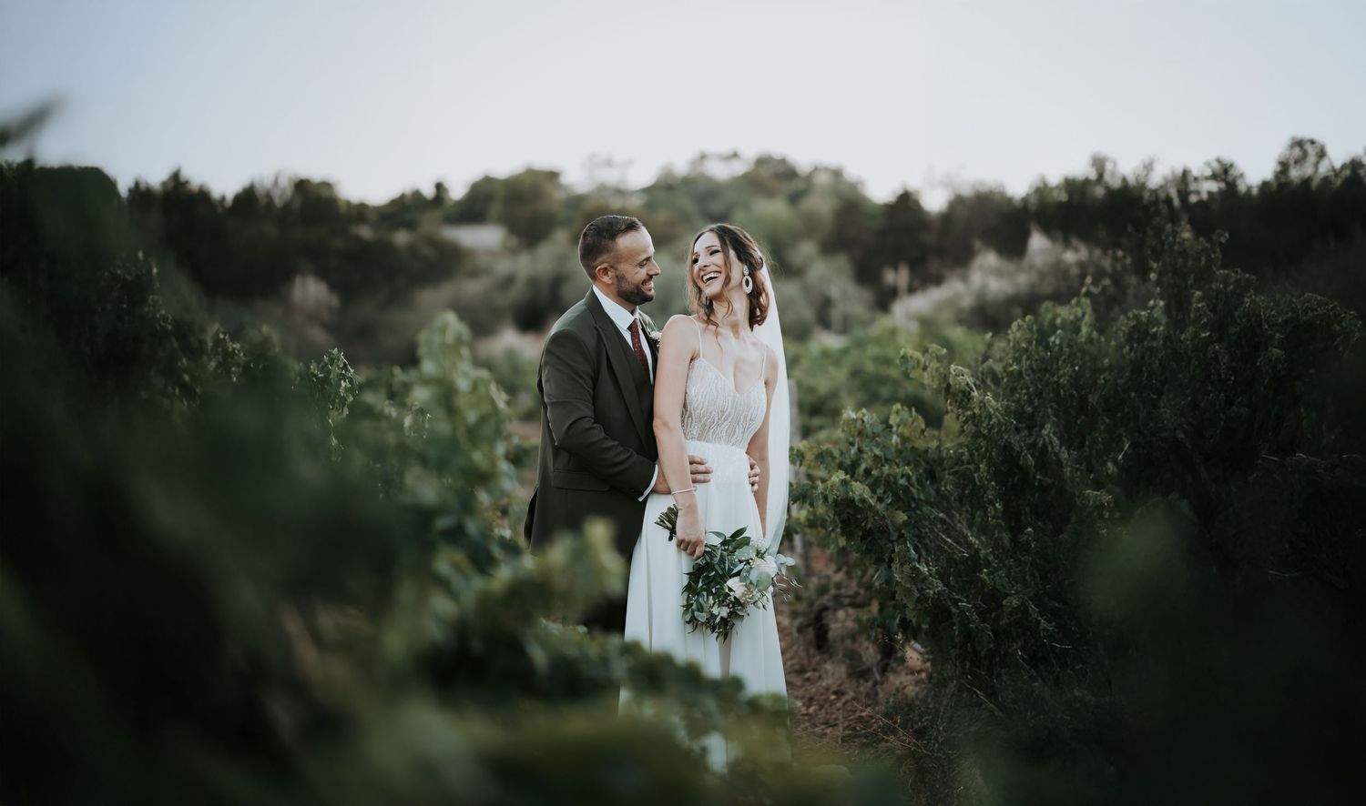 Scenic outdoor wedding ceremony setting with natural greenery and stone architecture.