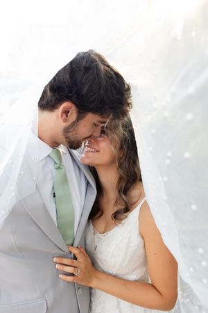 Bride and groom smiling at each other under the veil at Orland, California Wedding