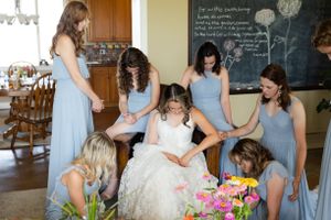 Bridesmaids praying with bride inside before the ceremony at at Orland, California Wedding