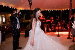 Bride twirling in dress while groom watches and decades band plays in the background at iron gate inn in chico, calif