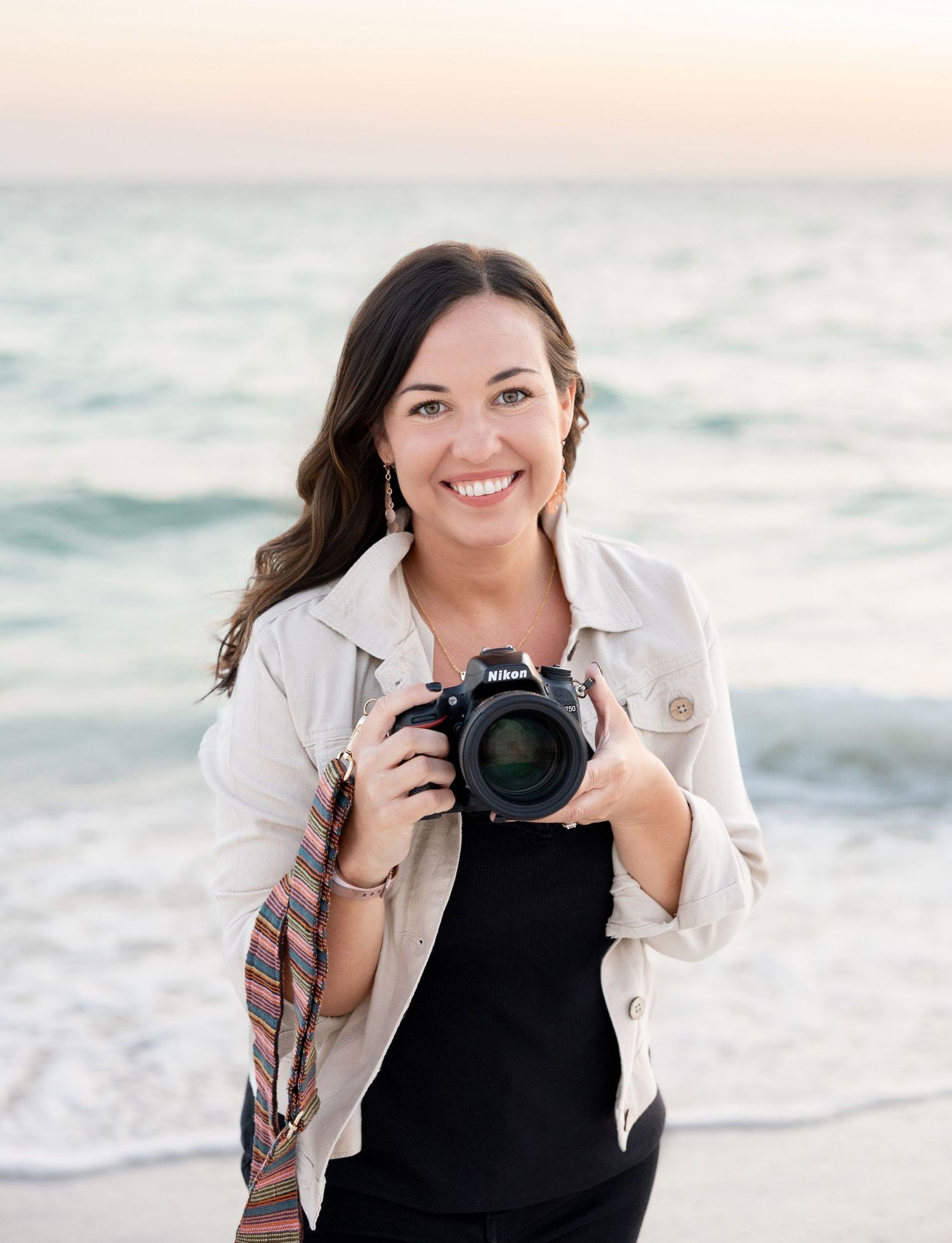 headshot photographer holding camera at the beach