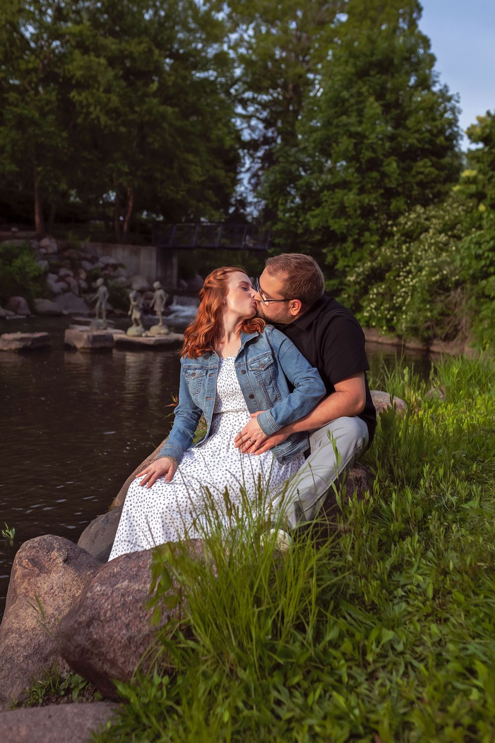 Romantic couple sitting by a pond with rocks and evergreen trees in the background.
Janesville, WI
Brodhead, WI