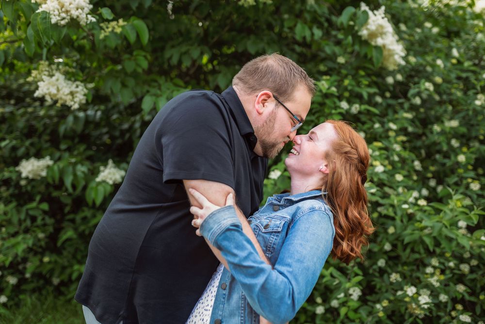 Couple embracing in front of blooming white flowers and green foliage.
Janesville, WI
Brodhead, WI