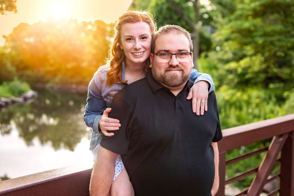 Sunset portrait of two people standing on a wooden bridge over water with warm backlighting.
Janesville, WI
Brodhead, WI