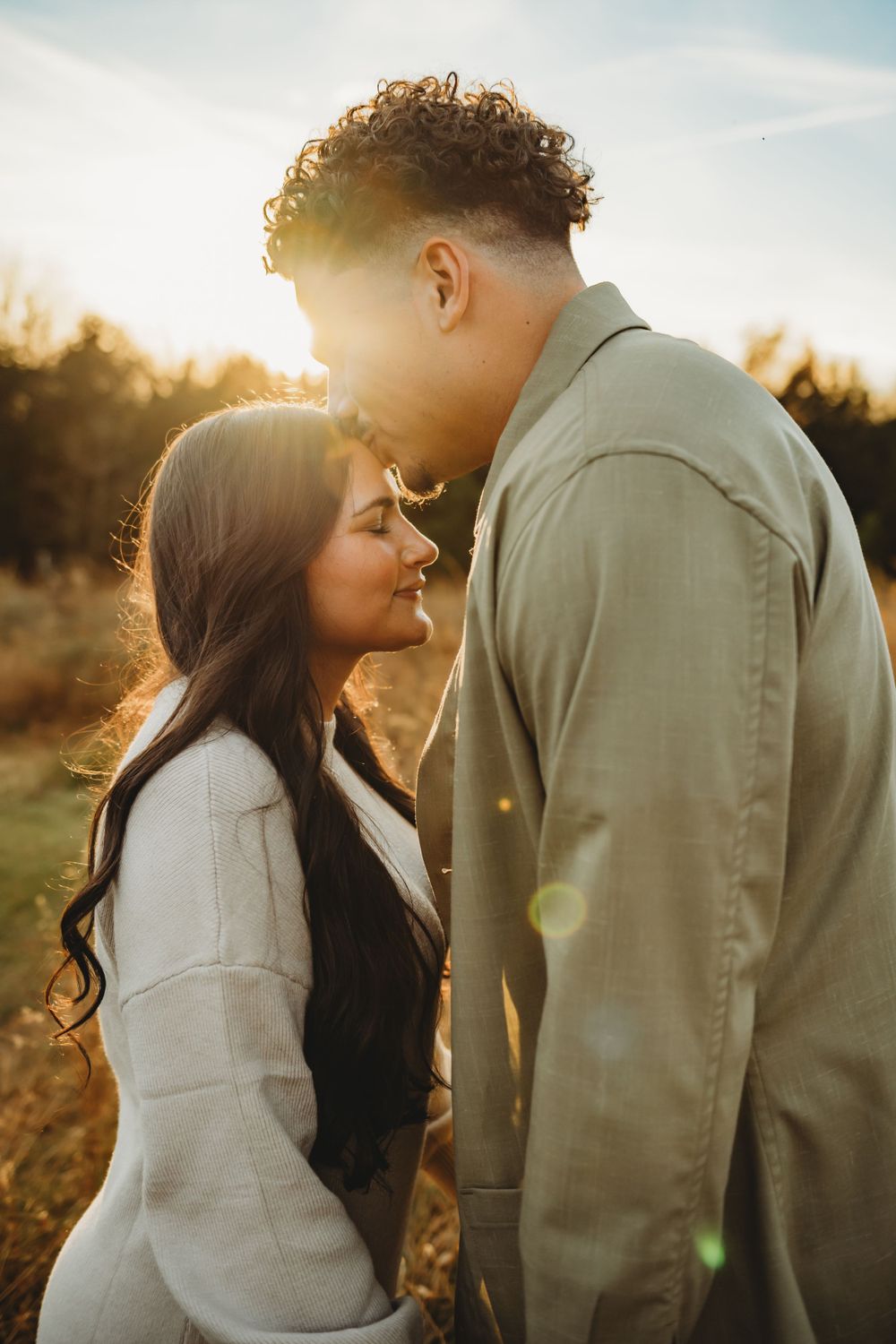 Romantic couple's portrait in warm sunset light with soft intimate poses.