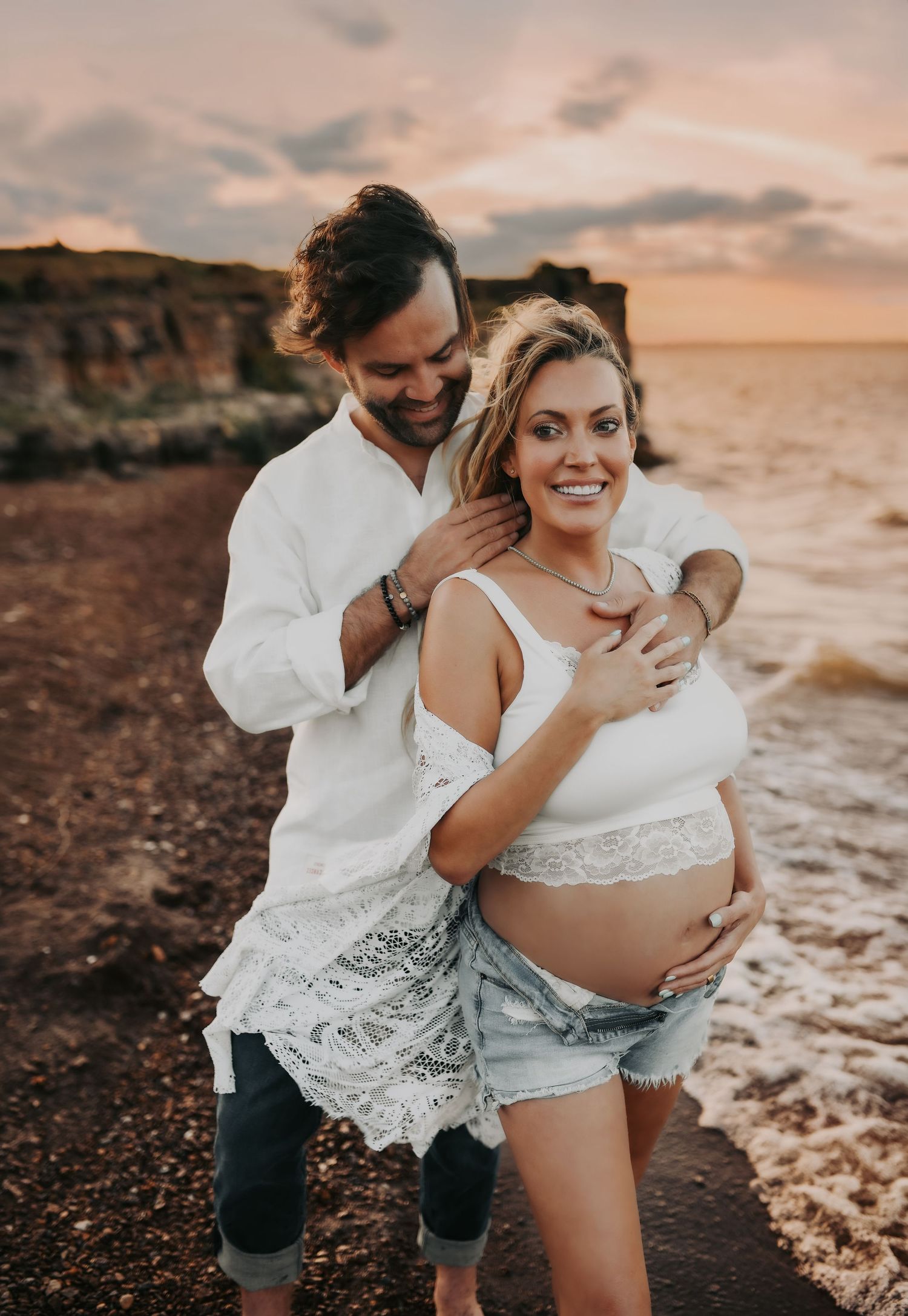Barefoot couple enjoying maternity session at sunset