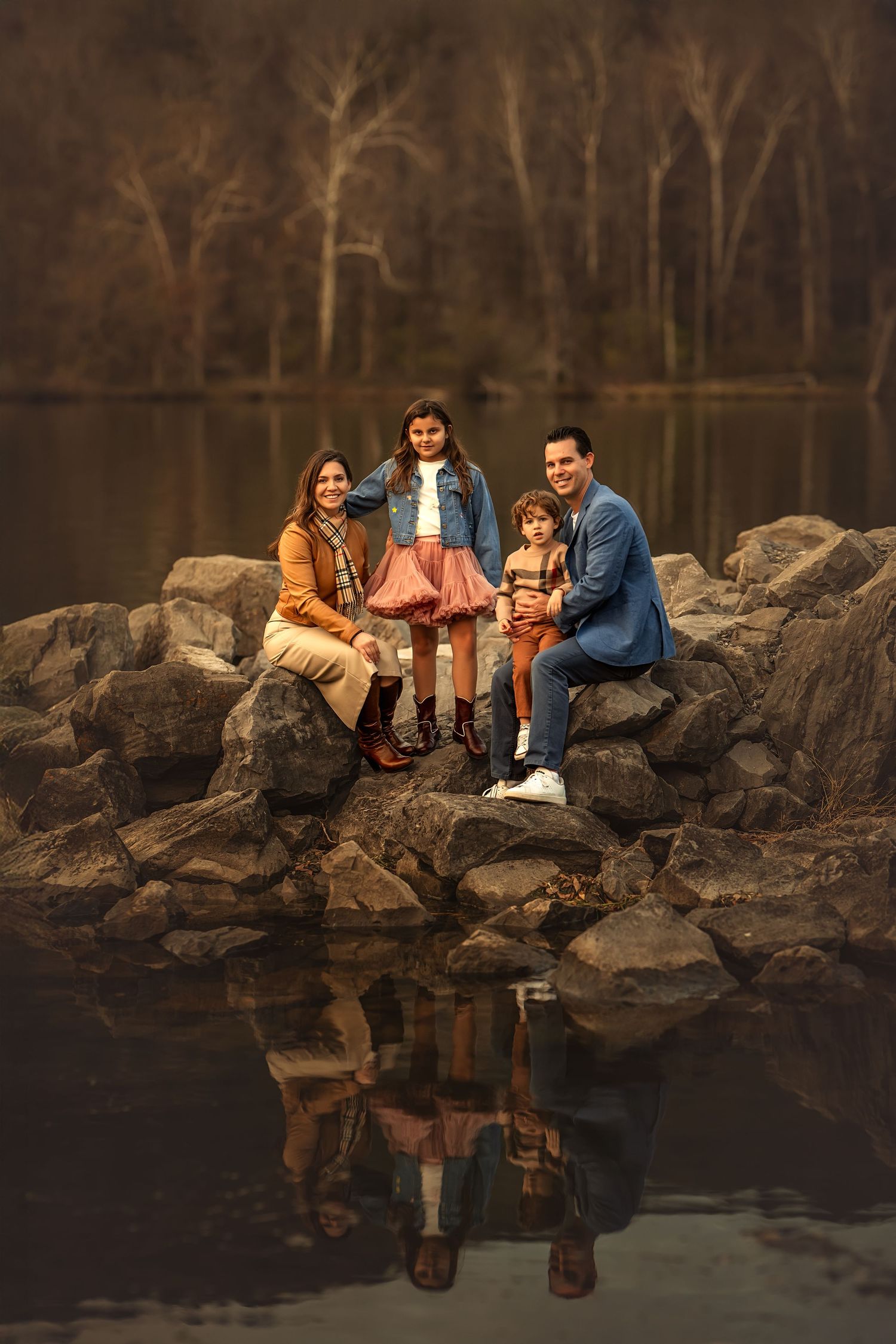 Family of five posing in a sunlit wildflower field during golden hour, wearing boho outfits in warm and pastel tones.