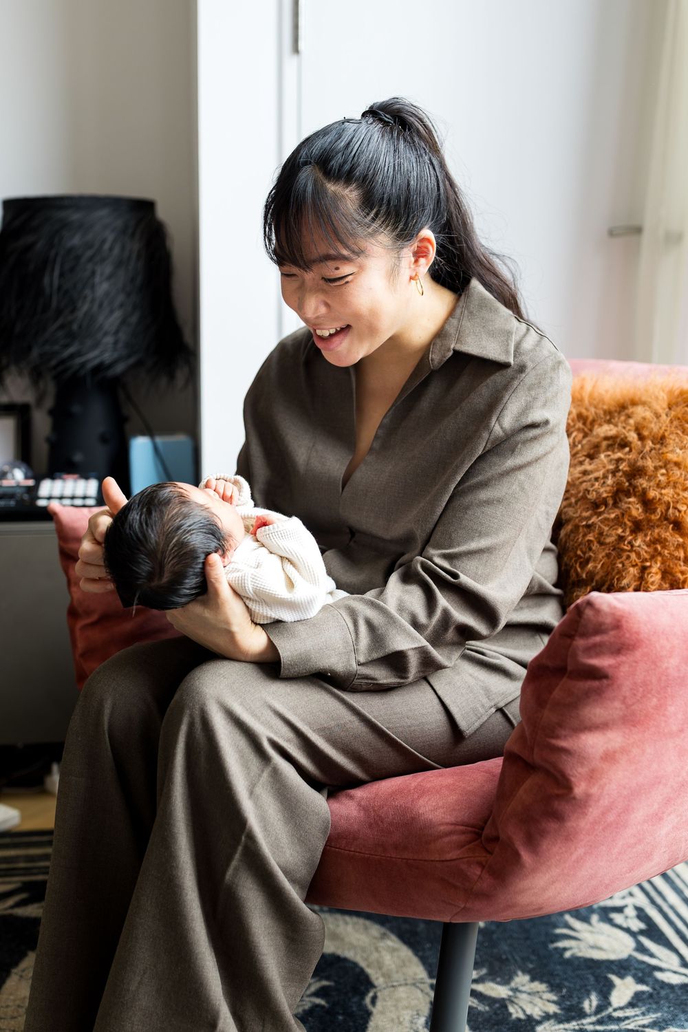 mum holding hew newborn baby on her lap