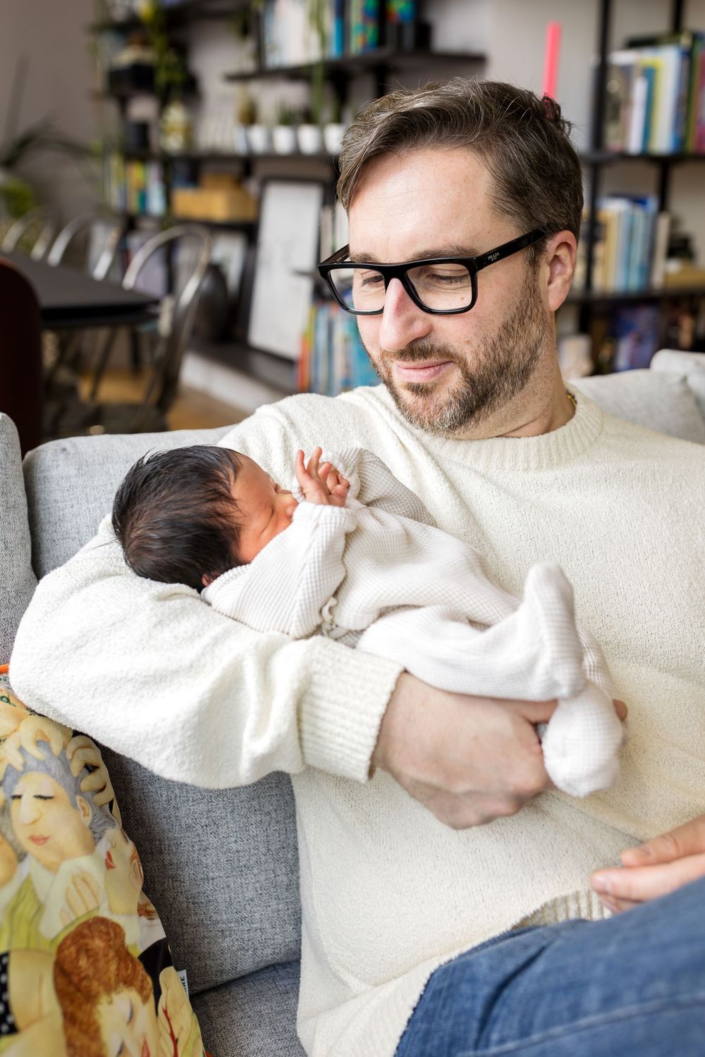 dad holding his newborn daughter in his arms