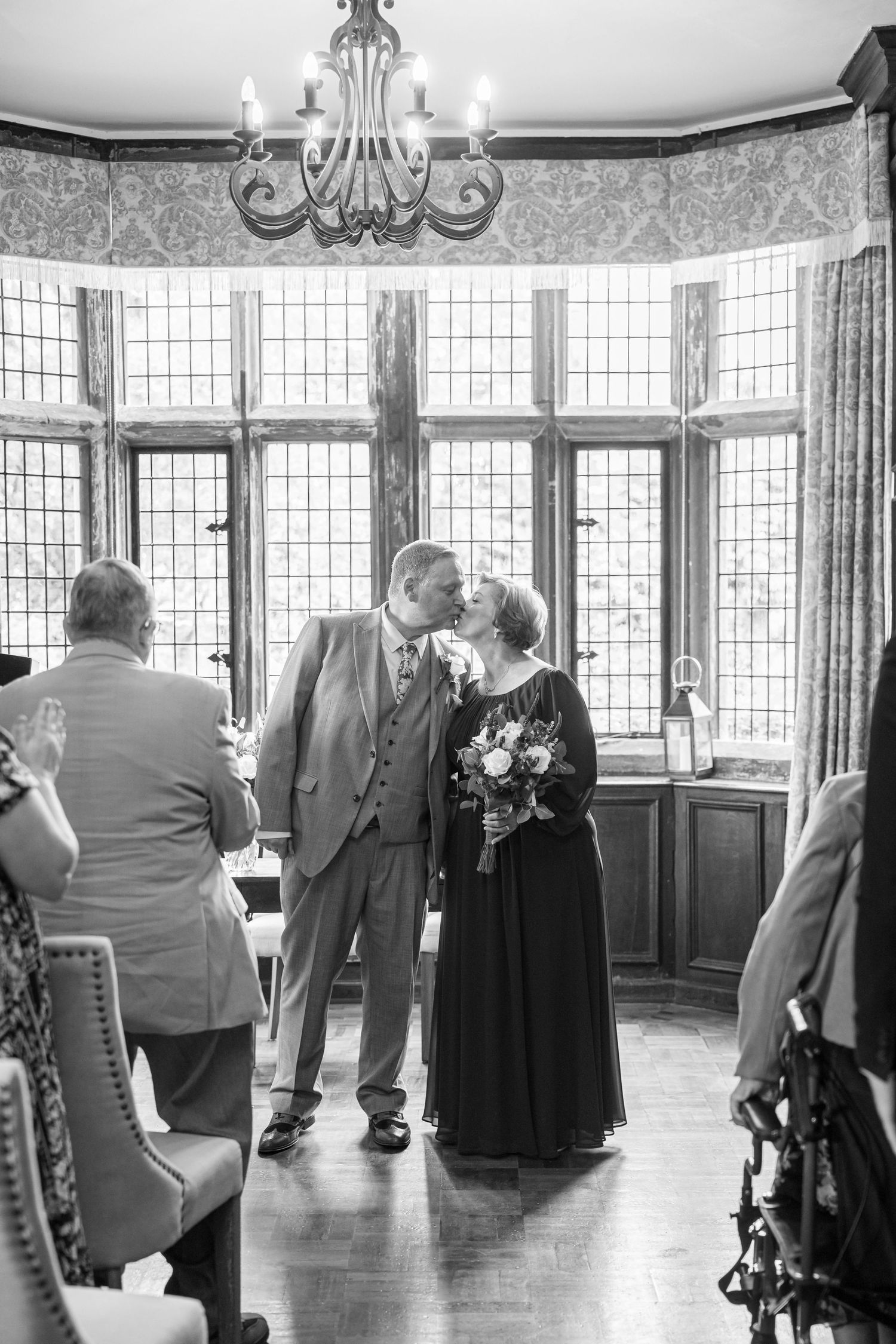 Bride walks down the aisle with her father in an elegant wood-paneled wedding ceremony venue.