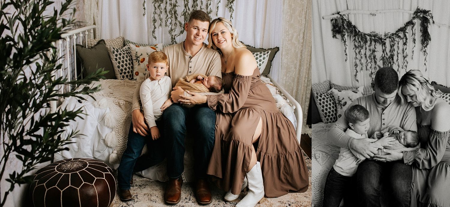 A family of four poses on a couch in a boho studio, with parents holding a newborn and a young toddler boy beside them.