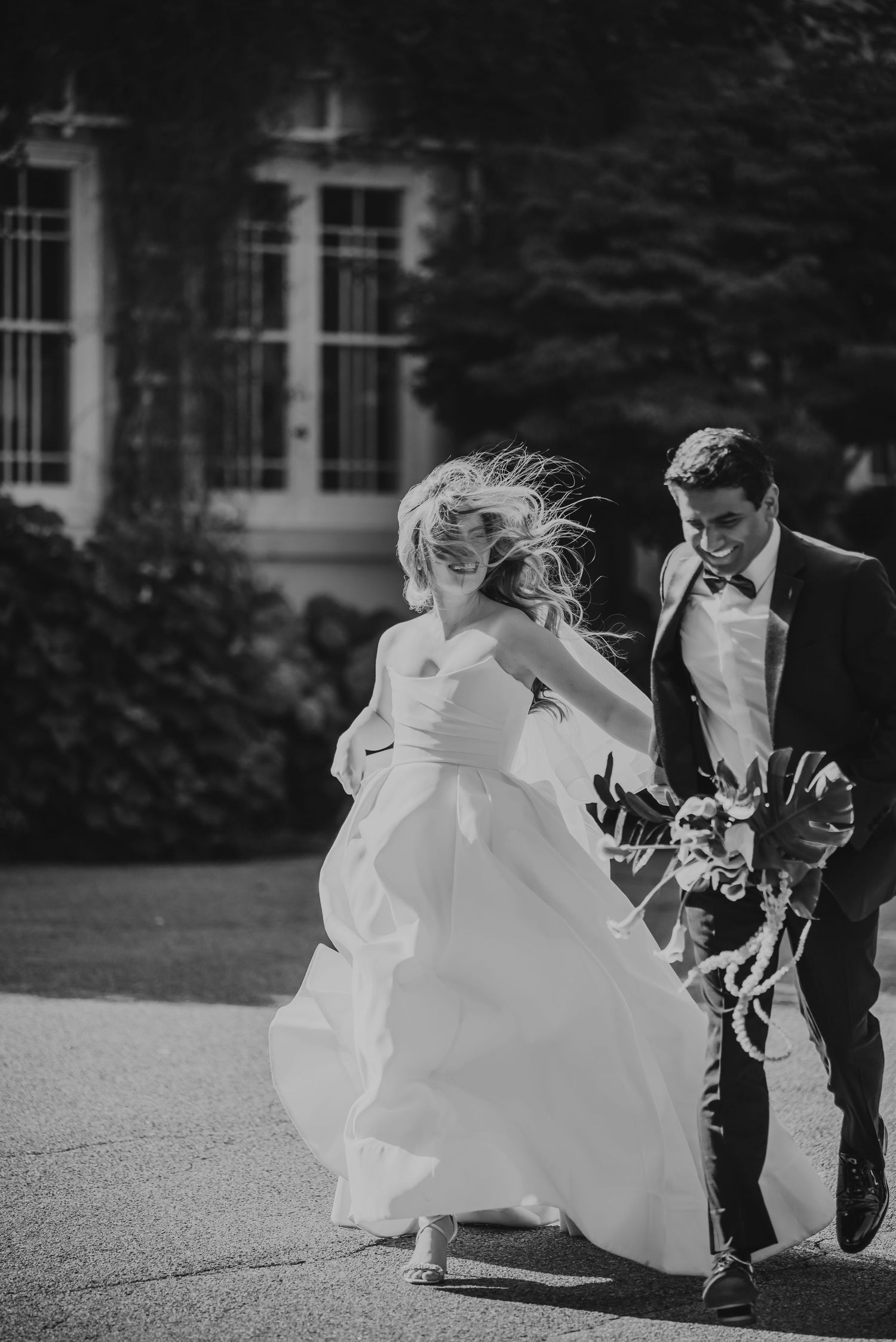 Bride and groom share a tender embrace on a staircase, captured from above, in wedding attire.