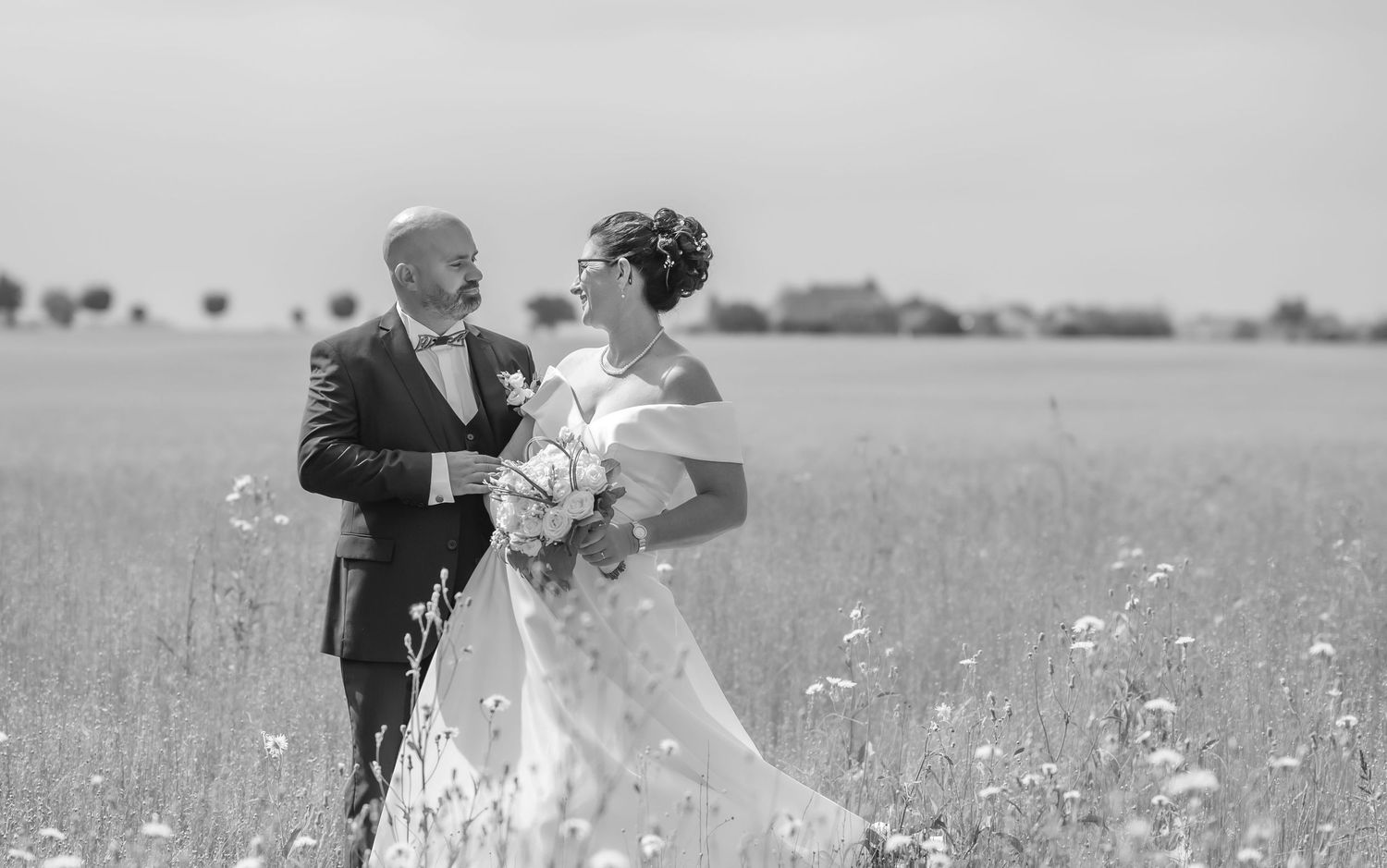 Photo de mariage en noir et blanc d'un couple dans les champs au chateau d'Écaussinnes en Belgique