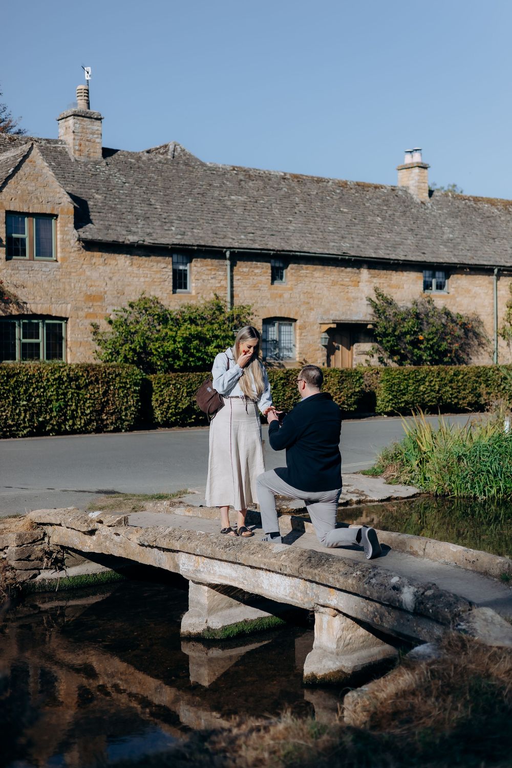 Groom proposing on the bridge in Lower Slaughter.