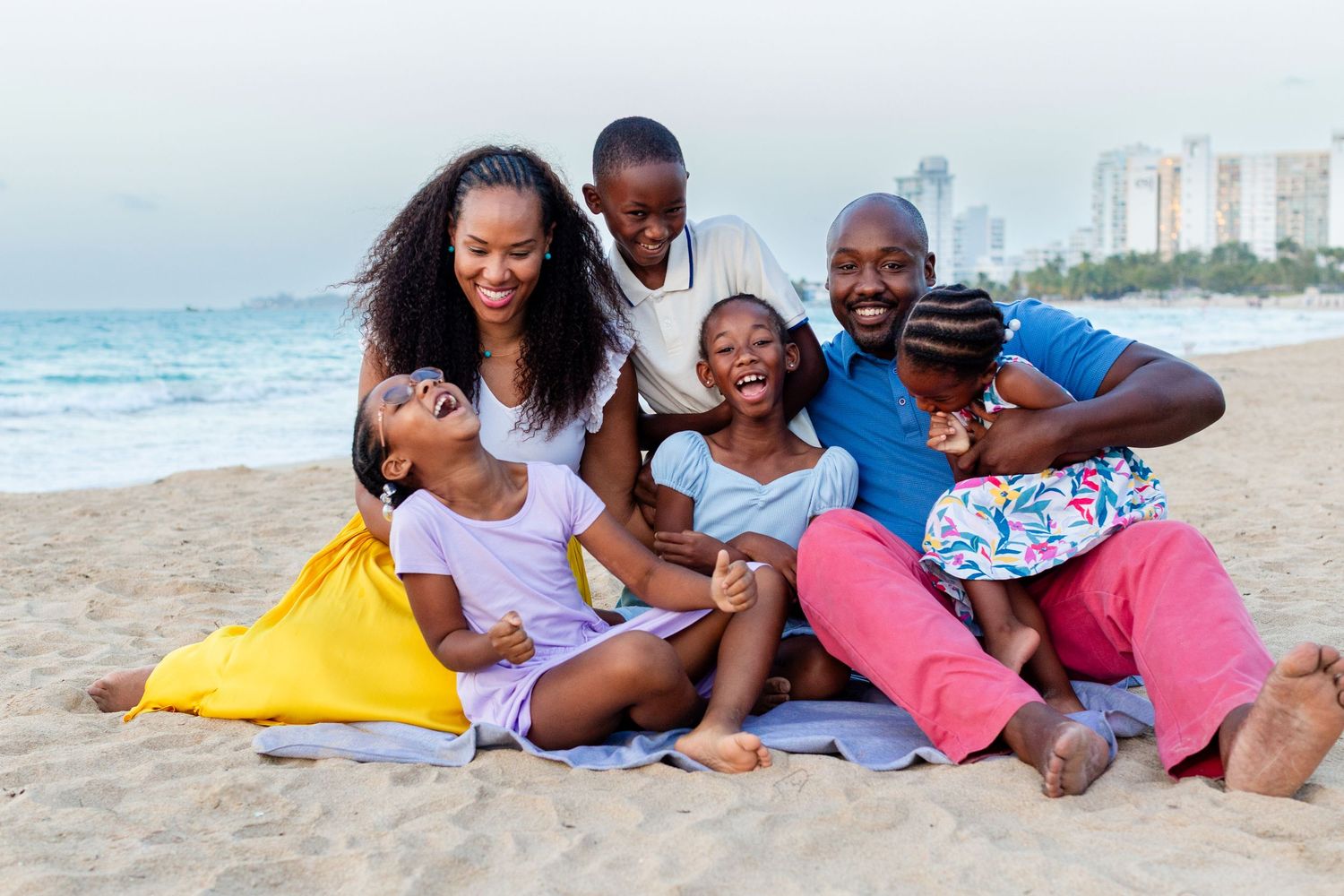 Family portrait. Mom, dad, and four kids seated on the beach in Isla Verde, Carolina, Puerto Rico.