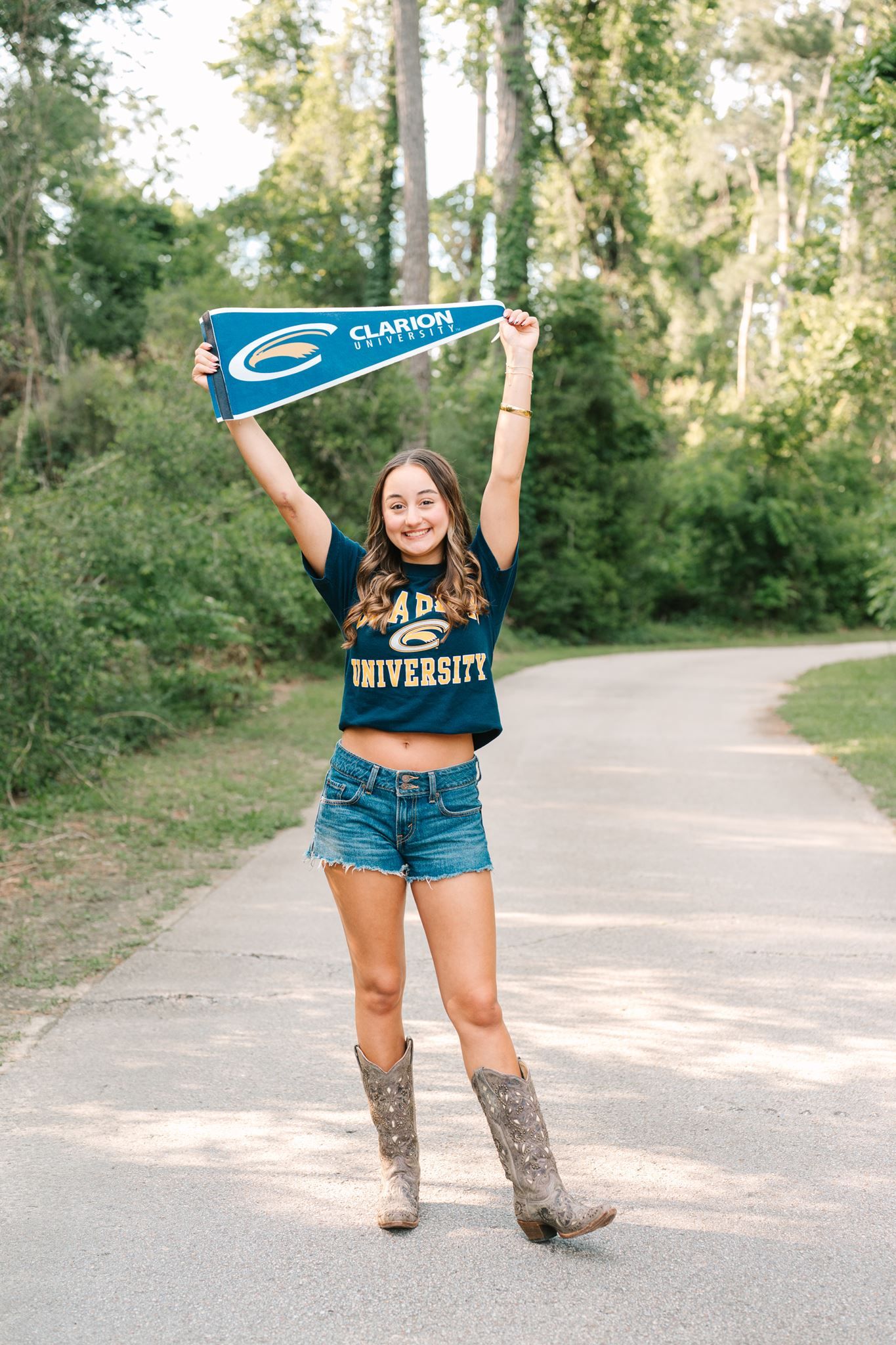 The Woodlands School senior girl posing with college pennant at Pundt Park in Spring Texas.