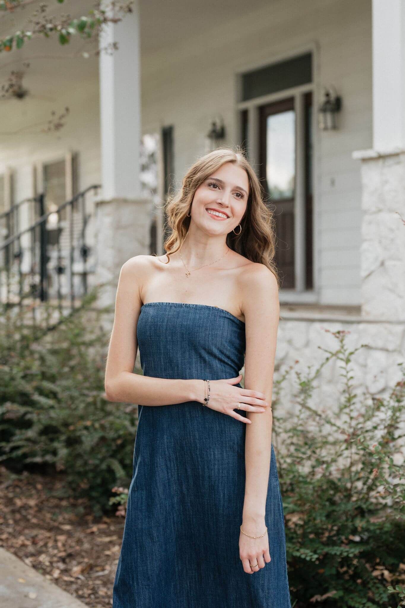 College Park High School senior girl posing in front of a southern style house in Magnolia Texas