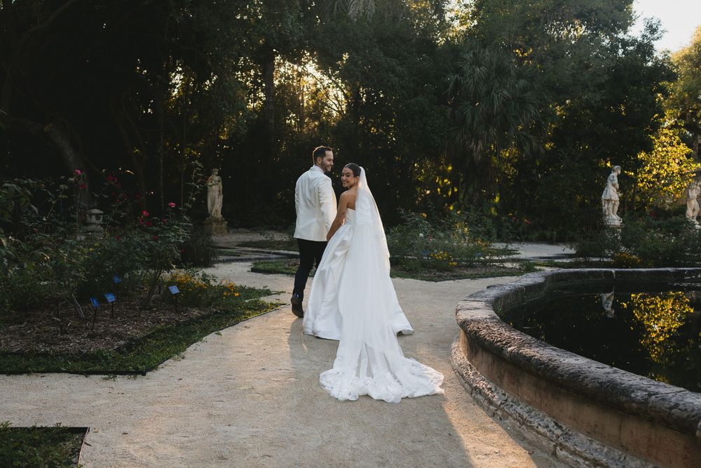 Bride and groom portrait in lush garden at golden hour.