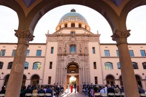 Outdoor wedding ceremony at Pima County Courthouse, Tucson, with guests seated under arches facing ornate Spanish Colonial dome.