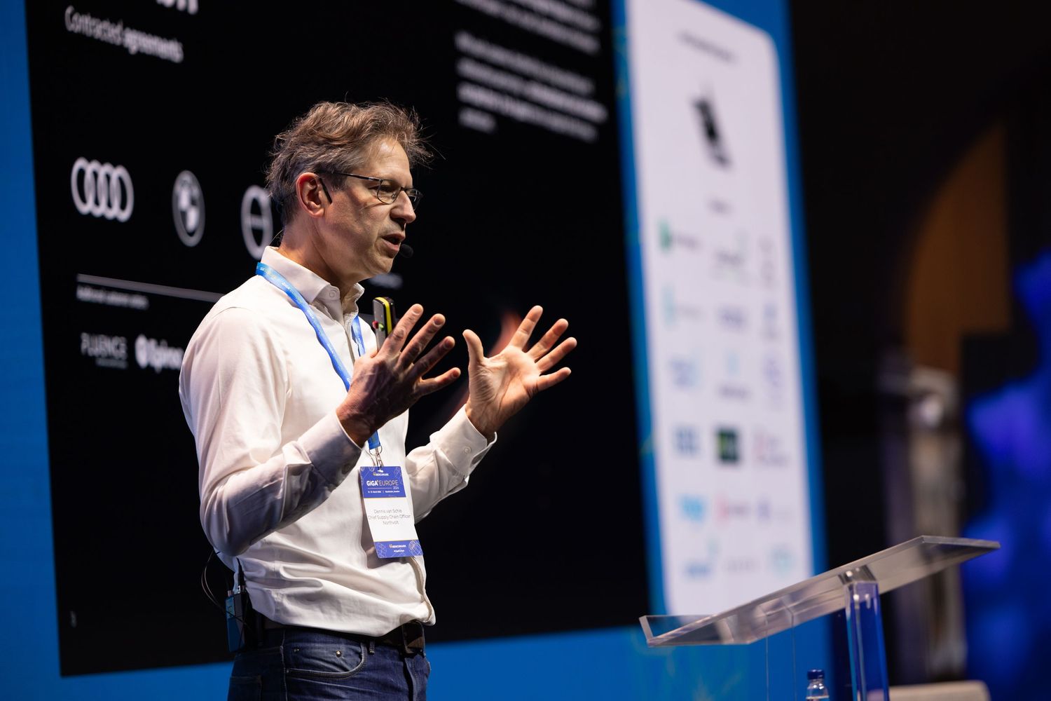 Male speaker presenting on stage at a tech conference.