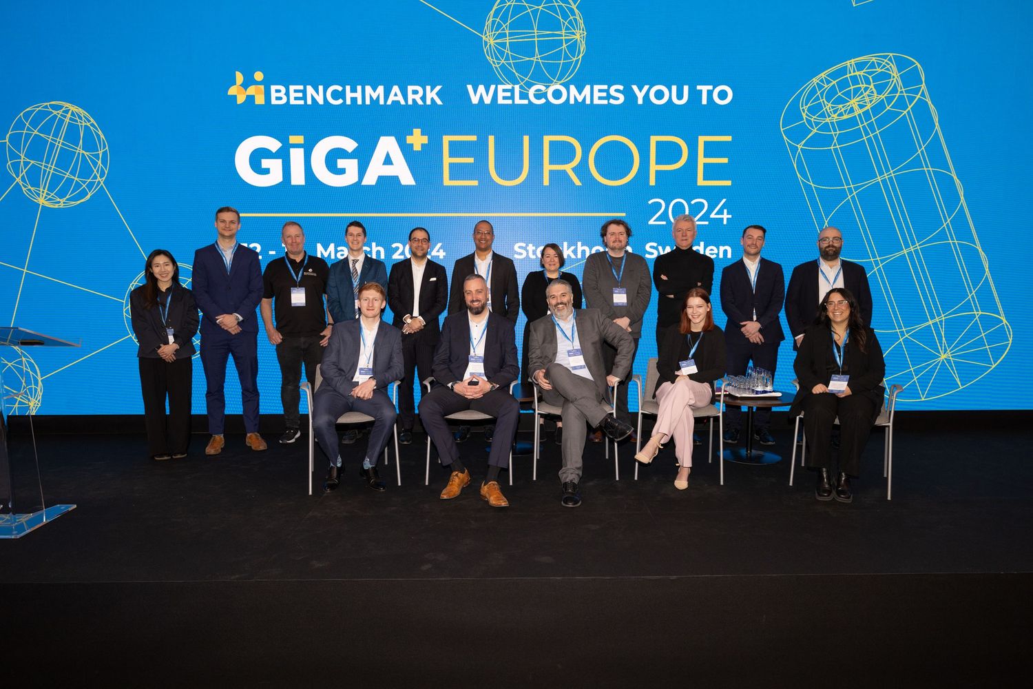 Group photo of attendees at GiGA Europe 2024 conference in front of a Benchmark welcome backdrop at Grand Hôtels Vinterträdgården.
