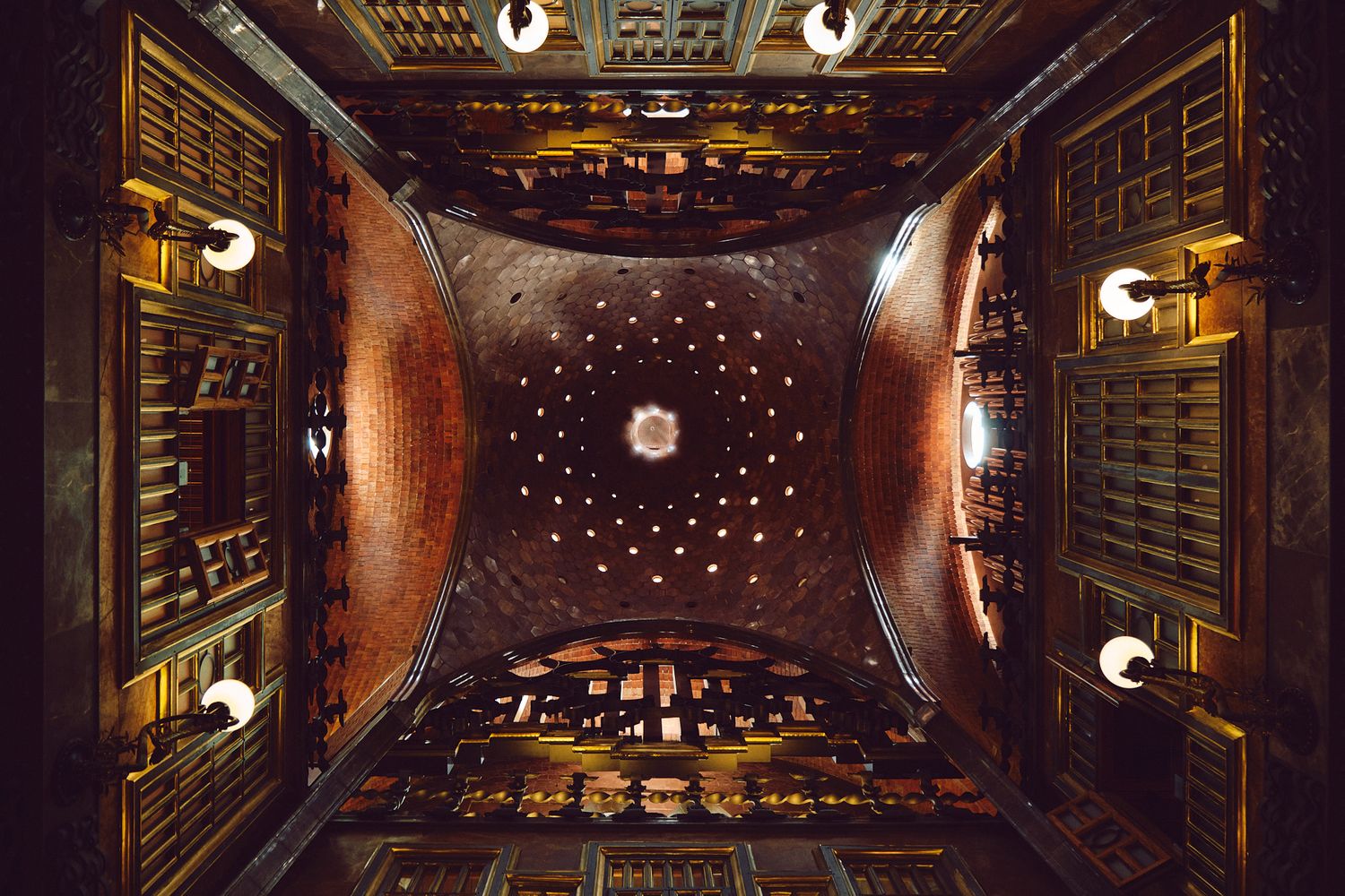 Ornate ceiling with geometric patterns, glowing lights, and intricate wooden details in a historic architectural interior.