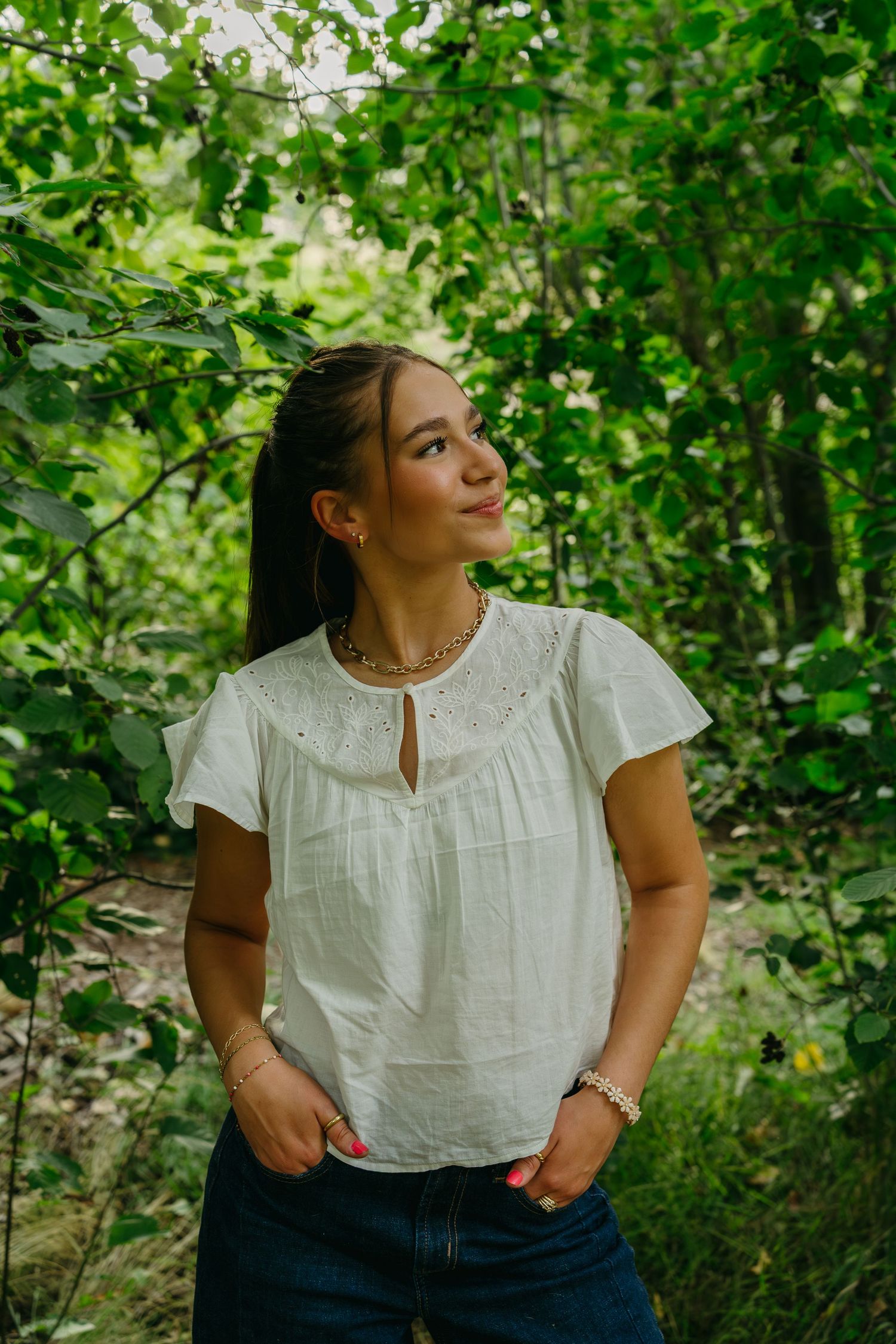Scenic senior portrait surrounded by lush foliage and soft golden light in Moscow, Idaho.