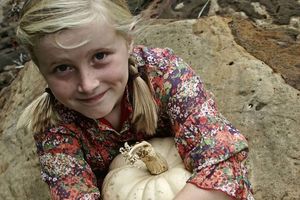 Young girl holds white pumpkin