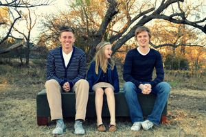Three siblings pose on a bench