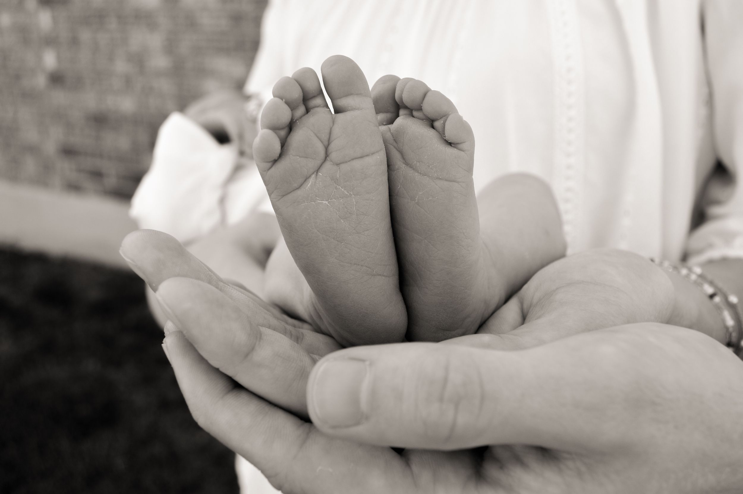 Baby feet being held by parents