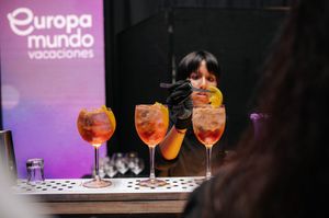 Bartender preparing colorful Aperol Spritz cocktails at Europa Mundo Vacaciones branded bar.
