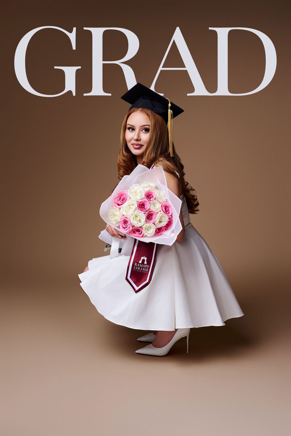 Magazine-style studio graduation portrait with "GRAD" text featuring a crouching RCNJ graduate holding flowers