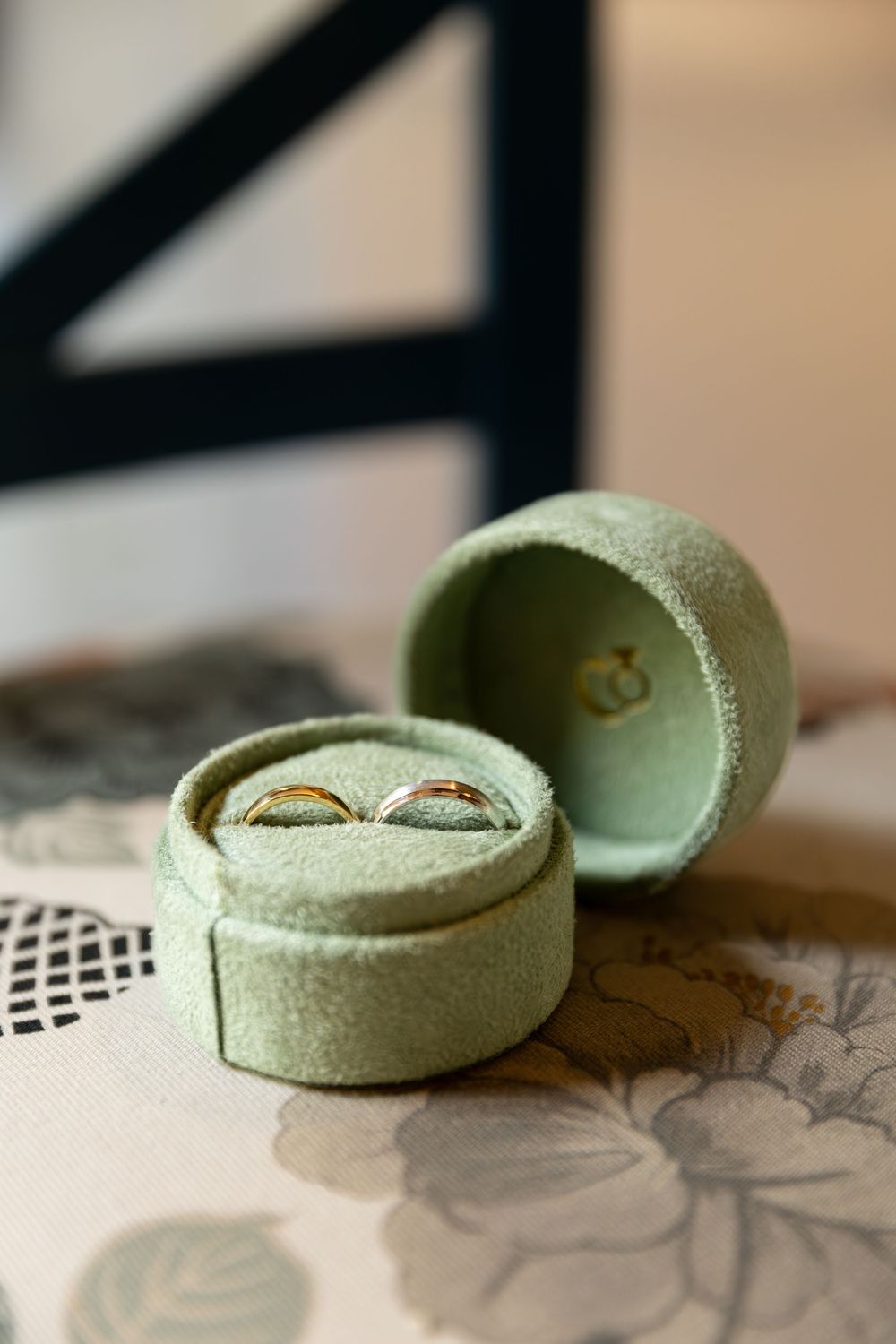 Wedding rings in a light green velvet box sitting on a chair in london, ontario wedding