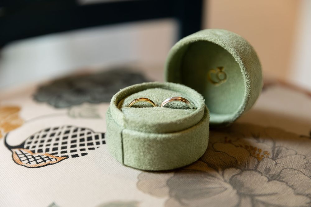 wedding bands in a green velvet box sitting on a chair during the morning of a wedding in london, ontario