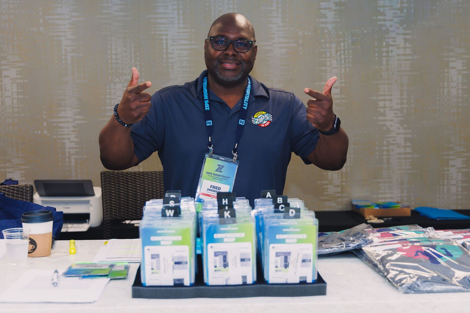 alt="Friendly conference registration desk attendant organizing badge packets at corporate event in Orlando Florida"