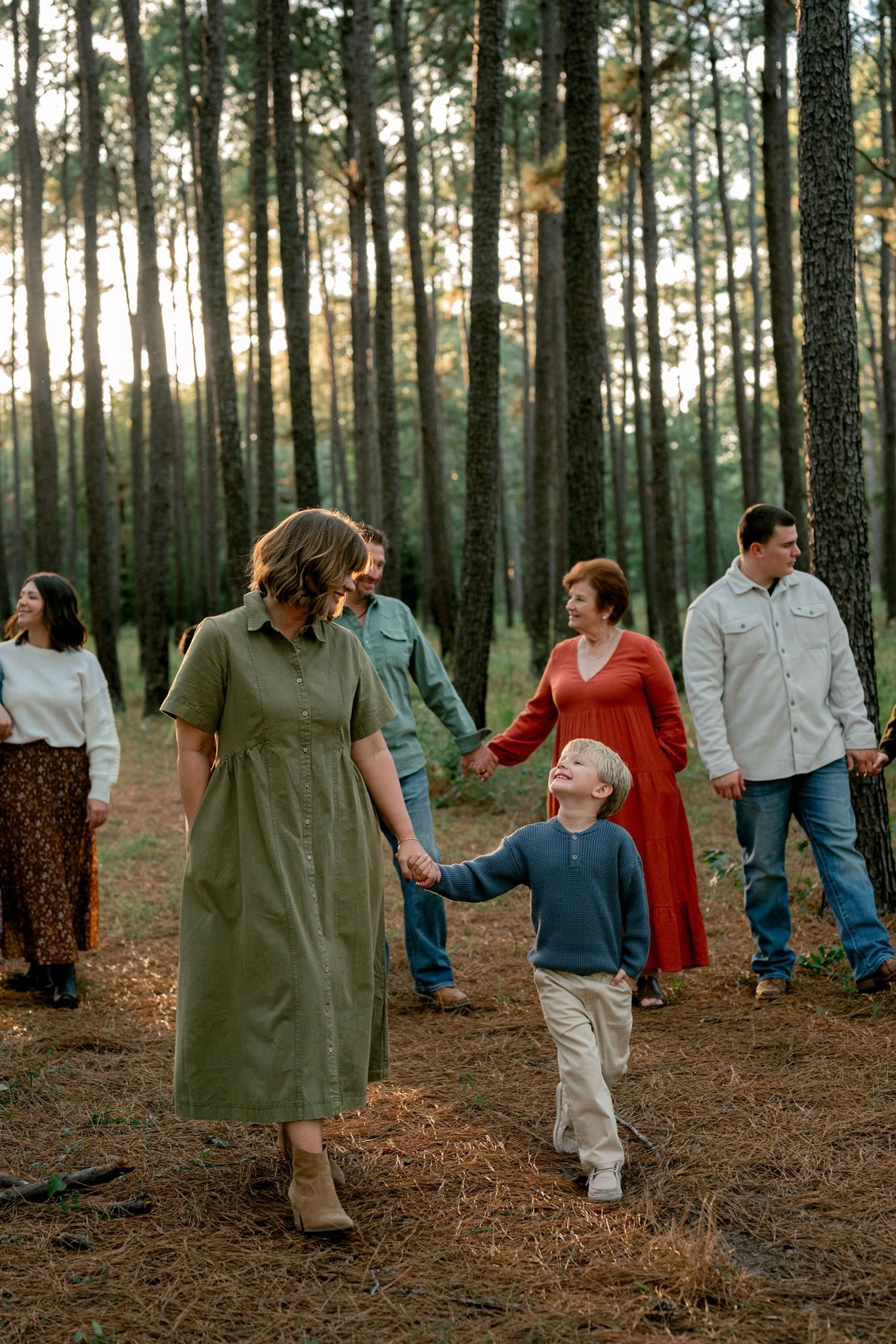 Extended family walking together through the forest during fall family portraits.
