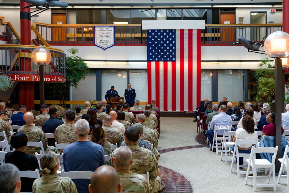 Large military retirement ceremony with audience seated before an American flag and podium.