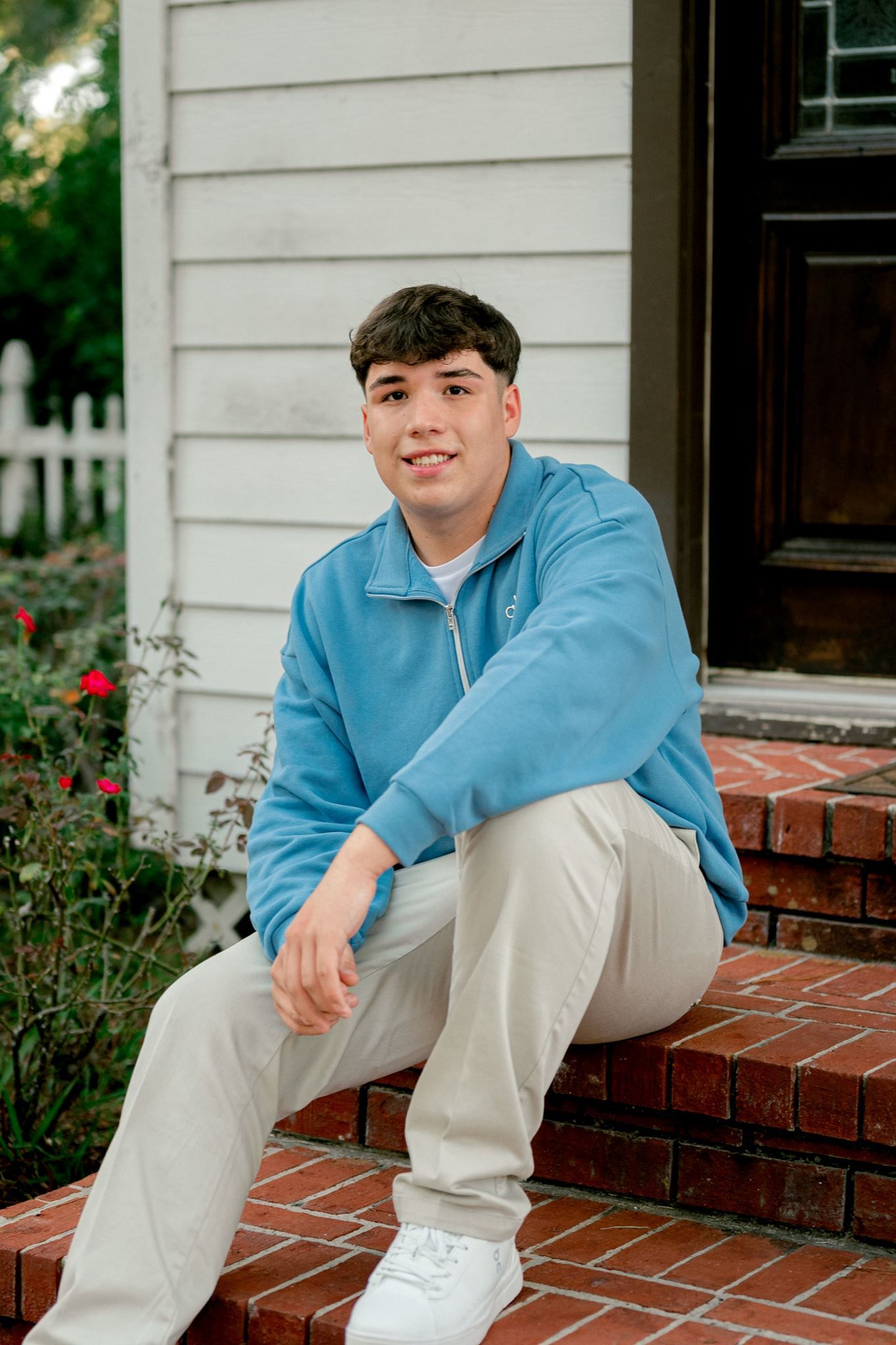 Senior guy sitting on steps for senior portraits.