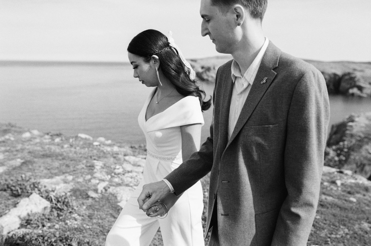 35 mm film photo of bride and groom walking hand in hand along Vancouver Island coast